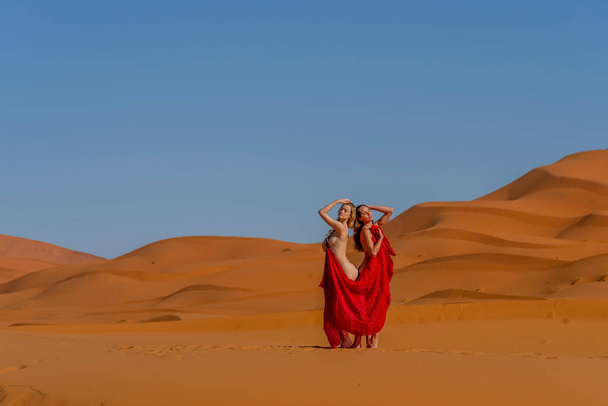 美しいモデルは、モロッコの偉大なサハラ砂漠の砂丘に対してヌードを提起します - 写真・画像