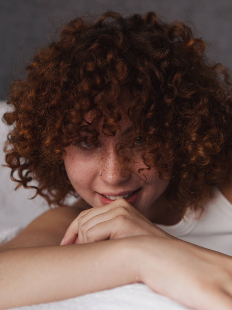 Beautiful girl with curly red hair on the bed in the morning  - Fotografie, Obrázek