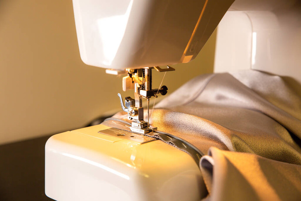 Máquina de coser y hermoso paño gris. Concepto de moda. Ideas de hobby. - Foto, Imagen