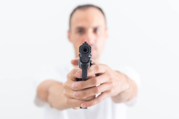 a man in a white t-shirt with a gun. - Fotoğraf, Görsel