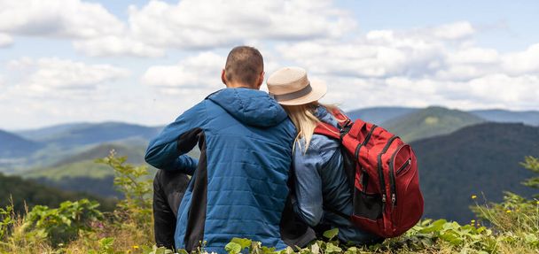 Pari matkustajat Mies ja nainen istuu rentouttava vuoret, tarkastella rakkautta ja matkustaa onnellisia tunteita elämäntapa käsite. Nuori perhe matkustaa aktiivinen seikkailu lomat. - Valokuva, kuva