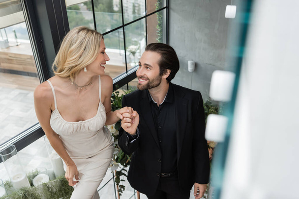 Smiling elegant couple holding hands in restaurant  - Fotografie, Obrázek