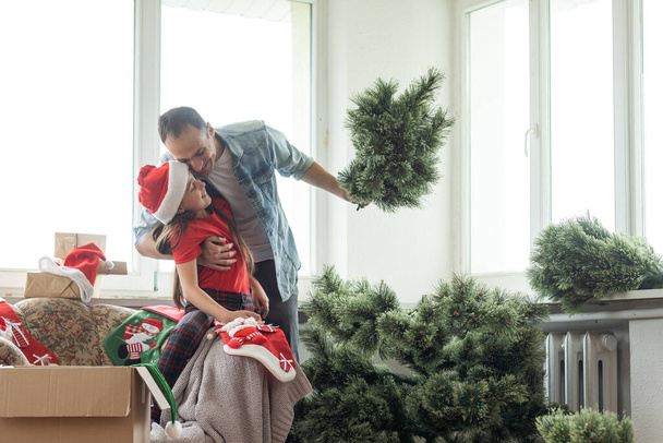 Padre e figlioletta che decorano l'albero di Natale in camera. - Foto, immagini