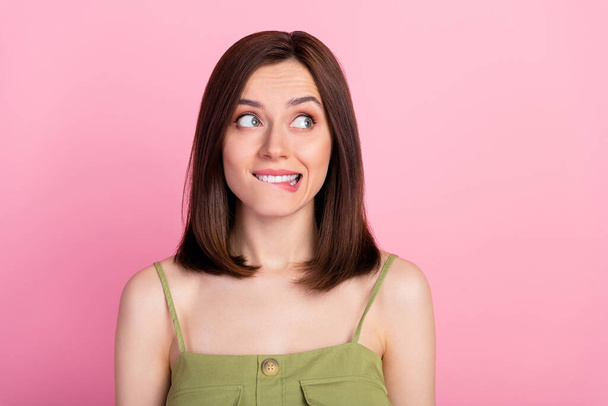 Photo of cute gorgeous adorable girl with bob hairstyle wear khaki top biting lips look empty space isolated on pink color background. - Φωτογραφία, εικόνα