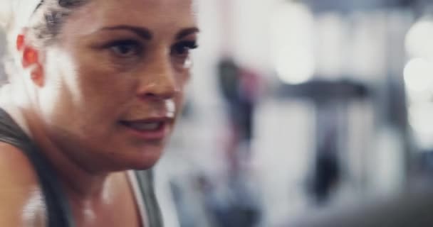 Active and real woman hitting a punching bag in real life at the gym to lose weight. Sweaty, candid and serious athletic female or normal person doing a boxing exercise to improve cardio and fitness. - Filmagem, Vídeo