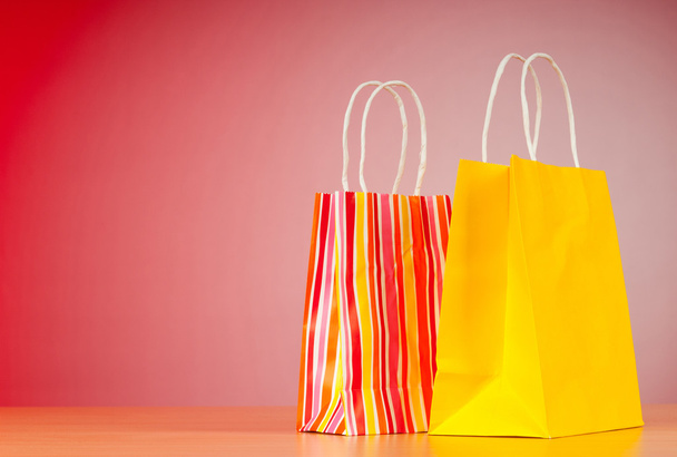 Colourful paper shopping bags against gradient background - Fotografie, Obrázek