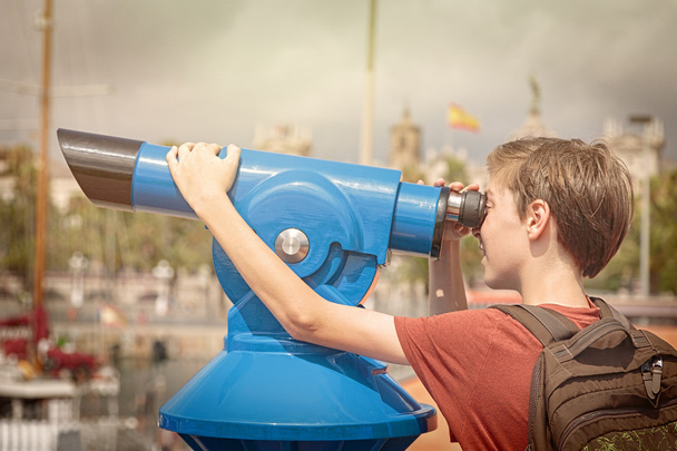 teenage boy with rucksack looking through a sightseeing monocula - Photo, Image