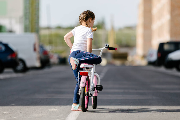 Little girl on a bicycle in summer park. cycling outdoors - Foto, afbeelding