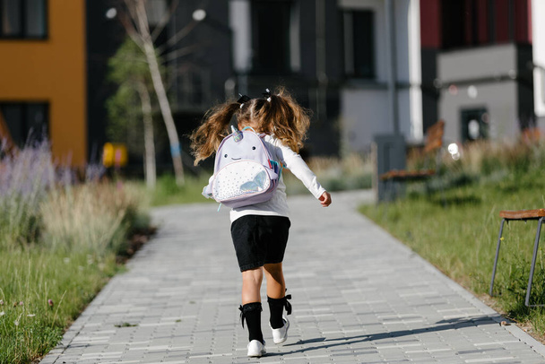 a little girl goes to school through the park along the path. distance education concept.  - Foto, afbeelding