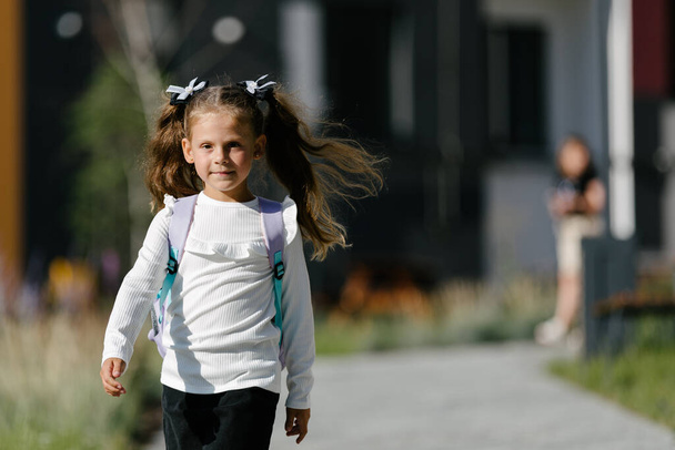 a little girl goes to school through the park along the path. distance education concept.  - Φωτογραφία, εικόνα