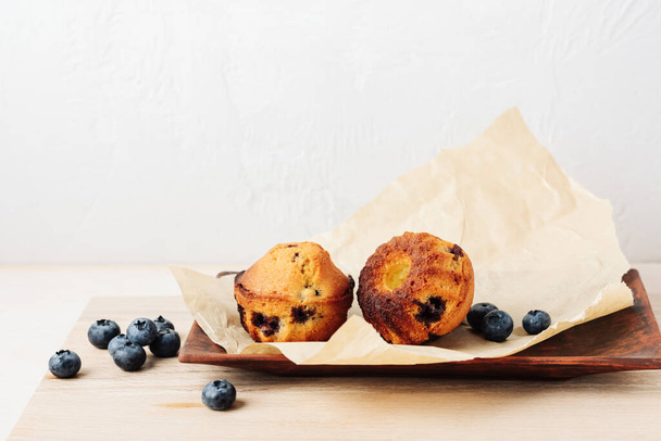 Two mini blueberry cakes on a tray. - 写真・画像