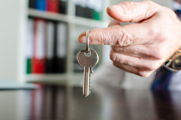 Agente inmobiliario mostrando llaves de la casa
 - Foto, Imagen