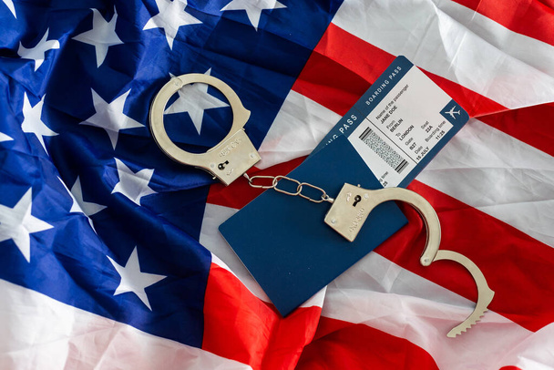 International passport with handcuffs on USA flag background. - Foto, Imagem