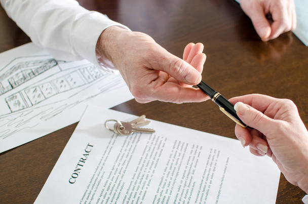 Agente immobiliare che dà una penna per la firma
 - Foto, immagini
