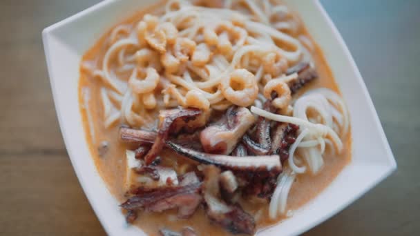Острый азиатский суп с лапшой, осьминогом и креветками. - Кадры, видео
