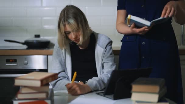 Teenage girl and her mother doing schoolwork at home. - Materiał filmowy, wideo