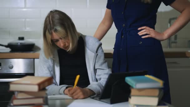Teenage girl and her mother doing schoolwork at home. - Video