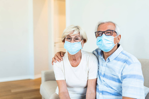 Senior couple wearing medical face mask recovery from the illness at the home. Senior couple with protective mask in quarantine at home during coronavirus covid-19 pandemic - Фото, зображення