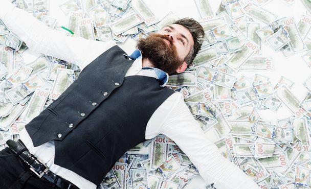 Businessman lying in many banknotes. Saving money. Business success. Rich millionaire, billionaire - Foto, Imagen