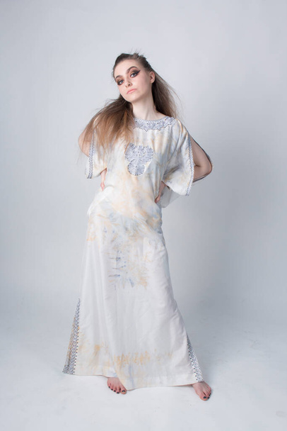 beautiful elegant female wearing a white African inspired dress - Fotó, kép