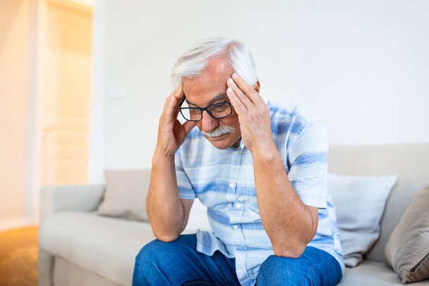 Attack of the monster migraine. Unhappy Retired Senior man holding his head with pain expression . Face of senior man suffering from headache - Fotoğraf, Görsel