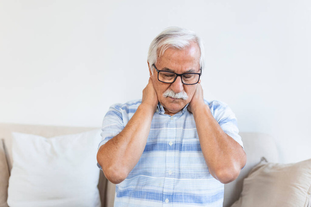 Senior man feeling exhausted and suffering from neck pain, Health concept. Sad senior man with neckache. Elderly man with chronic pain syndrome fibromyalgia suffering from acute neckaches. - Photo, Image