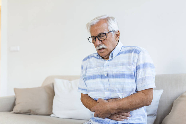 Old man having strong abdominal ache, health problems. Senior man with stomach pain - Fotoğraf, Görsel