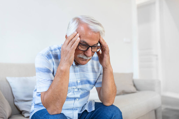 Attack of the monster migraine. Unhappy Retired Senior man holding his head with pain expression . Face of senior man suffering from headache - Foto, imagen