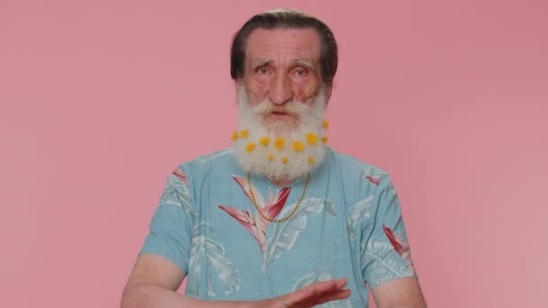Displeased upset man reacting to unpleasant awful idea, dissatisfied with bad quality, wave hand, shake head No, dismiss idea, dont like proposal. Elderly grandfather on pink studio wall background - Materiał filmowy, wideo
