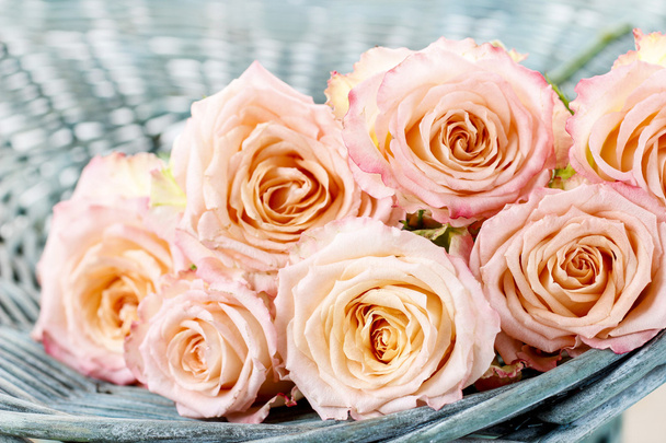 ροζ τριαντάφυλλα σε τυρκουάζ ψάθινο καλάθι - Φωτογραφία, εικόνα