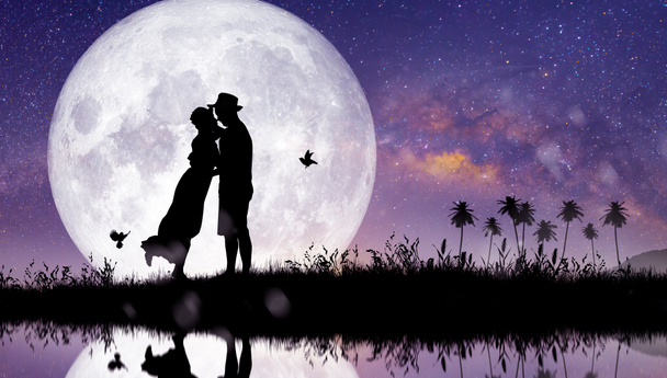 Силуэт в ночном пейзаже пара или любовник танцует и поет на горе с Milky Way фона в полнолуние. - Фото, изображение