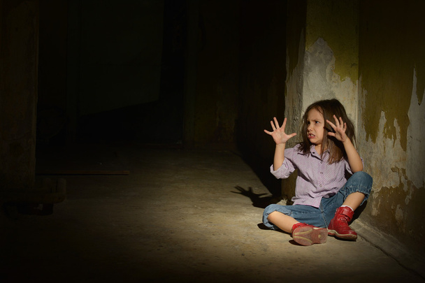 Lonely little girl in a dark cellar - Fotoğraf, Görsel