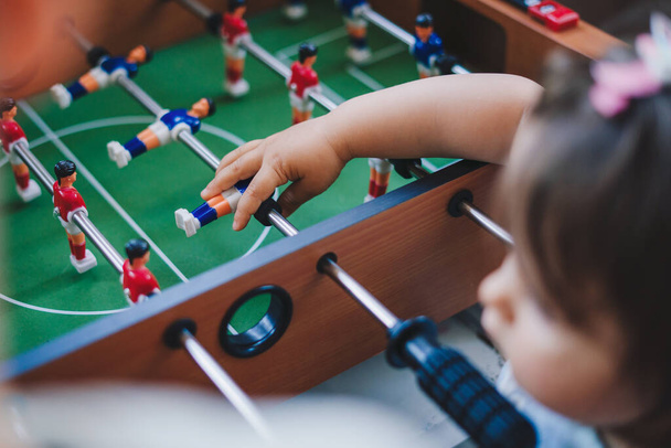 Little boy and girl enjoying playing football table toy. Happy family, childhood. Children play table games. - 写真・画像