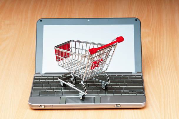 Internet online shopping concept with computer and cart - 写真・画像