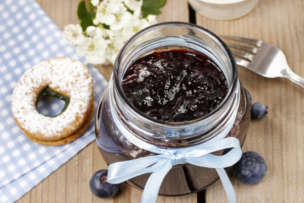 Jar of blueberry jam decorated with blue bow - Foto, afbeelding
