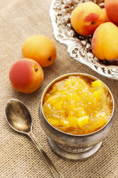 Bowl of apricot jam and ripe apricots in the background - Фото, изображение