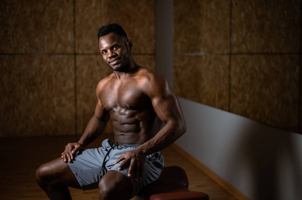 Handsome afro american shirtless man posing in the gym - Photo, image