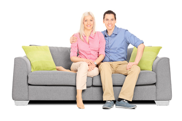 Молода пара сидить на дивані
 - Фото, зображення