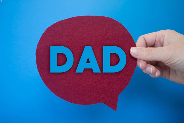 Speech bubble in front of colored background with Dad text. - Foto, Bild