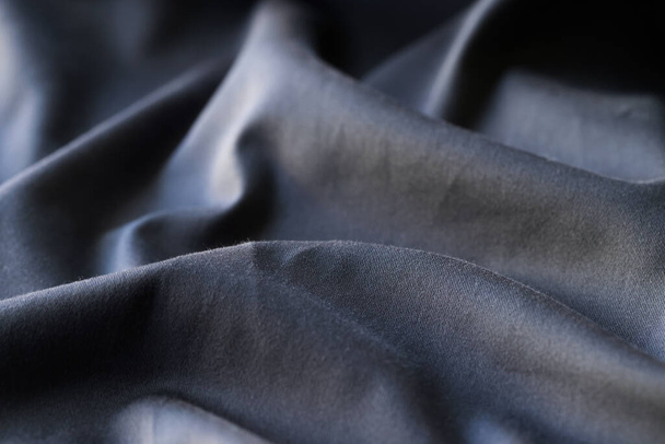 Top view of black wavy fabric textured background, cloth texture backdrop. Dark cloth for sewing. Beautiful crumpled pattern - Foto, Bild