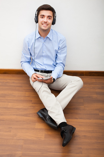 Man sitting on floor with earphones - Foto, Imagem
