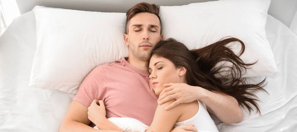 Νεαρό ζευγάρι κοιμάται στο κρεβάτι, κορυφαία άποψη   - Φωτογραφία, εικόνα