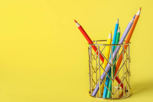 Golden cup with pencils on yellow background - Fotografie, Obrázek