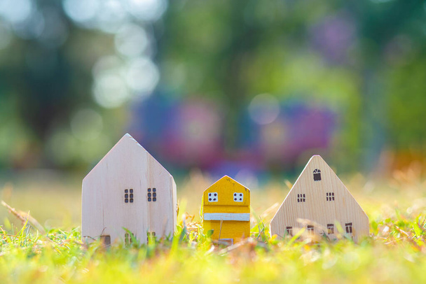Modern ahşap ev oyuncağı çimen üzerinde güneş ışığı gerçek konsept - Fotoğraf, Görsel
