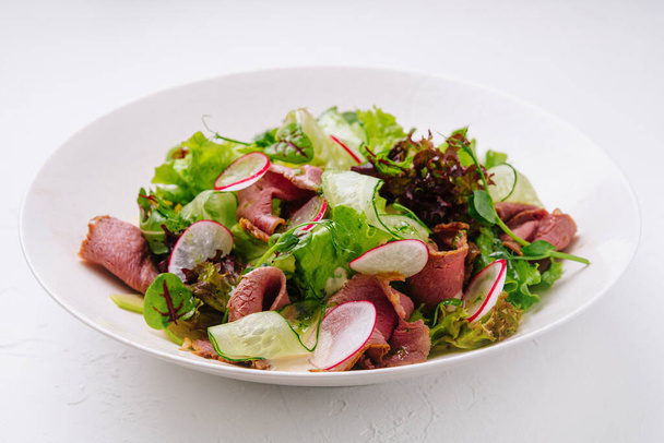 Roast beef salad with green mix on plate - Photo, Image