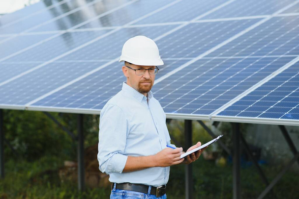Solar energy. Young business man near the solar panels to power plants - Photo, Image