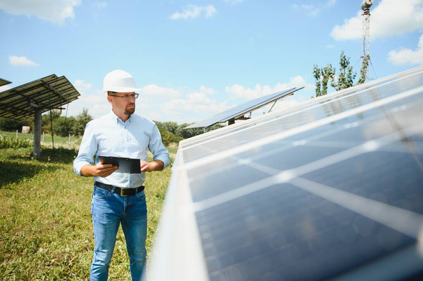 Engineer at solar power station with solar panel. Practical lessons on renewable energy power plants - Φωτογραφία, εικόνα