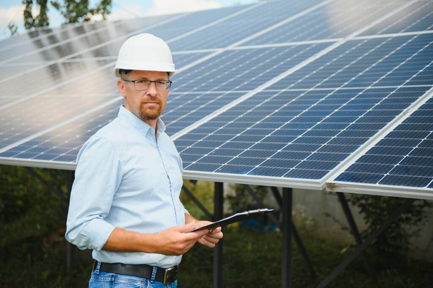 Engineer at solar power station with solar panel. Practical lessons on renewable energy power plants - Fotoğraf, Görsel