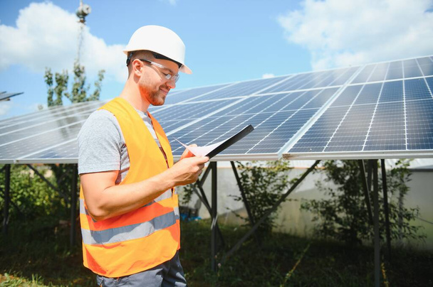 Worker installing solar panels outdoors. - 写真・画像