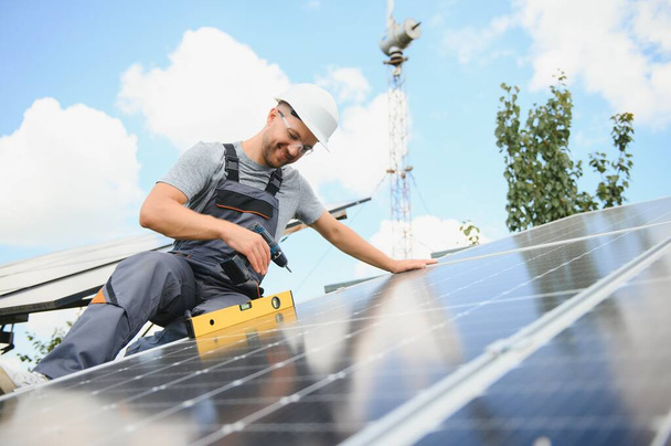Worker installing solar panels outdoors. - Fotó, kép